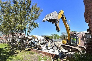 A worker with Beshears Construction operates an excavator Thursday as part of a demolition and restoration project at the Creekmore Park Pool in Fort Smith. The City of Fort Smith announced it hired Beshears and Crafton Tull to replace the 75-year-old bathhouse and diving well with a modern bathhouse and covered diving well that will host premier swim meets as a new municipal swimming facility, in addition to improving public facilities. According to the city, the pool will remain open to the public over the summer on a modified schedule while construction continues. Visit rivervalleydemocratgazette.com/photo for today's photo gallery.
(River Valley Democrat-Gazette/Hank Layton)